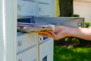 Person getting direct mail from mailbox